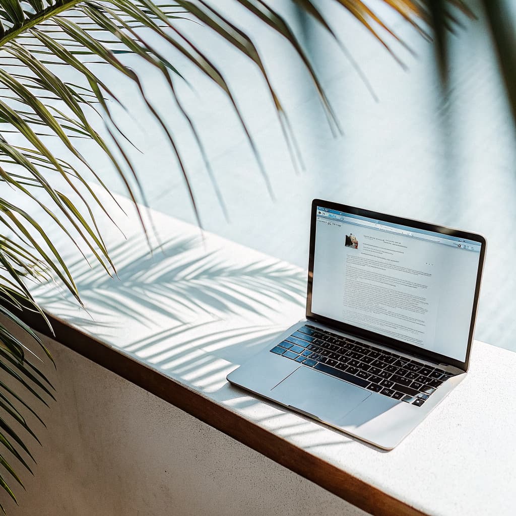 Laptop with an email campaign open on a sunlit Florida patio desk